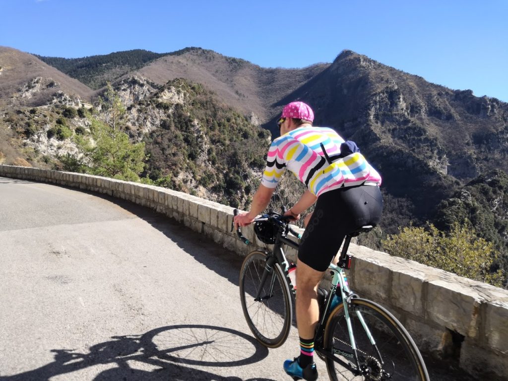 Nice - cyclist with colourful jersey climbing the mountain road